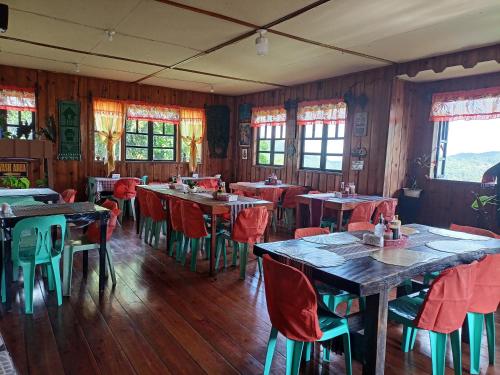 a dining room with tables and chairs and windows at Las vegas lodge and restaurant in Banaue