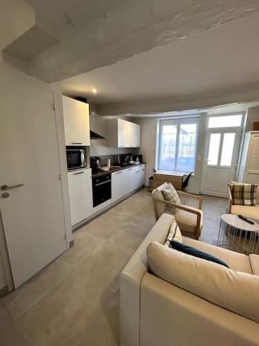 un salon avec un canapé et une cuisine dans l'établissement Neptune - SILS, à Douvres-la-Délivrande