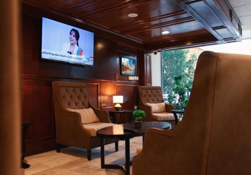 a waiting room with chairs and a tv on a wall at فندق السليمانيه والرمال الزرقاء in Riyadh