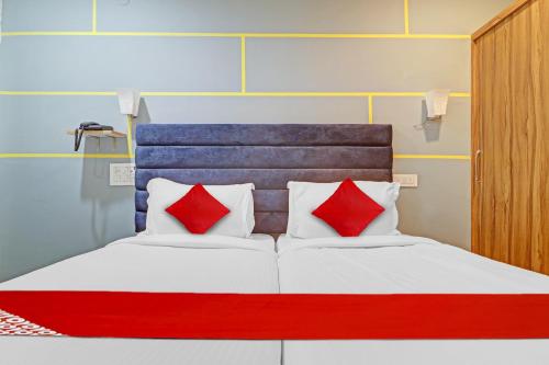 a bed with red and white pillows in a room at OYO Flagship Luxury Rooms in Hyderabad