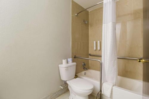 a bathroom with a toilet and a shower and a tub at Clarion Pointe Lake Jackson - Clute in Lake Jackson