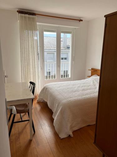 une chambre avec un lit, un bureau et une fenêtre dans l'établissement Maison des dunes proche plage, à Quiberon