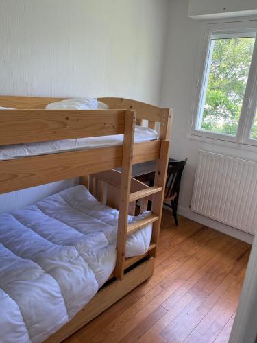 deux lits superposés dans une chambre avec fenêtre dans l'établissement Maison des dunes proche plage, à Quiberon