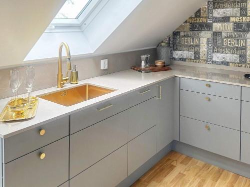 a kitchen with white cabinets and a sink at Holiday home HELSINGBORG in Helsingborg