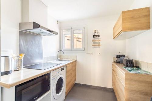 une petite cuisine avec un lave-linge et un sèche-linge. dans l'établissement La Clé T3 Clim, WiFi Balcon et Confort à Toulon, à Toulon