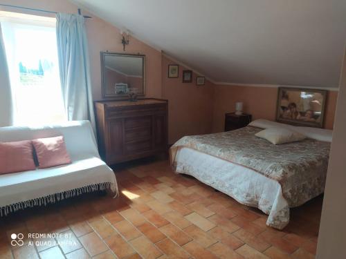 1 dormitorio con cama, silla y espejo en B&B L'Uliveto, en Montebuono