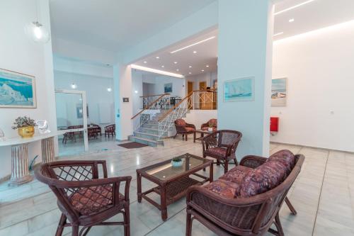 een woonkamer met stoelen, een tafel en een trap bij Jasmine Hotel in Kos-stad