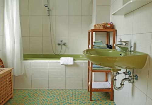 a bathroom with a green sink and a tub at Das Meininger Ferienhaus in Meiningen