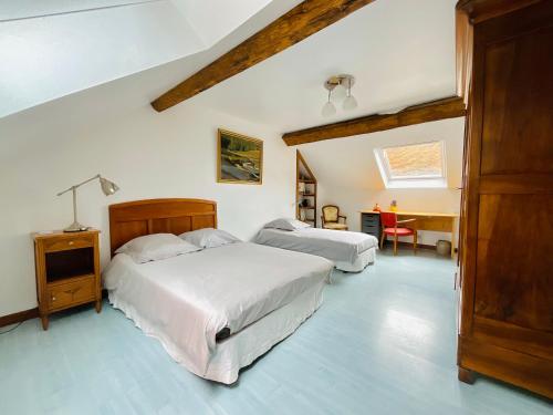 a bedroom with two beds and a table and a desk at Rue de la Tour du Pin in Fontaine-Française