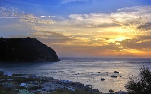 a view of the ocean with a sunset in the background at Hotel Riva del Sole in Ischia