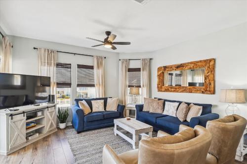 uma sala de estar com sofás azuis e uma televisão em Sandpiper Cove 9232 condo em Destin