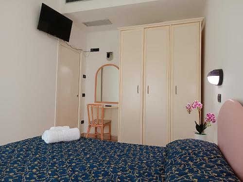 een slaapkamer met een bed, een kast en een tafel bij Residence Queen Mary in Cattolica