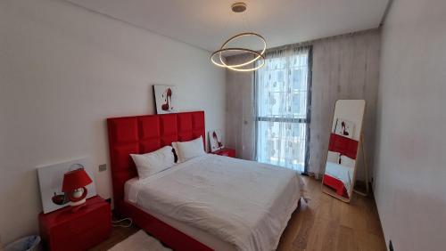 - une chambre avec un grand lit et une tête de lit rouge dans l'établissement Anfa Place, à Casablanca