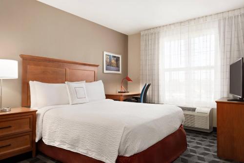 a hotel room with a bed and a television at TownePlace Suites by Marriott Springfield in Springfield