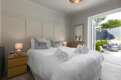 a bedroom with a large white bed with towels on it at Willows in St Ives
