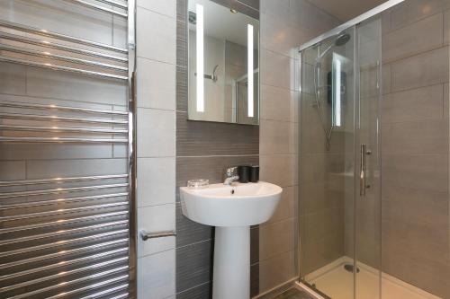 ein Bad mit einem Waschbecken und einer Dusche in der Unterkunft Willows in St Ives