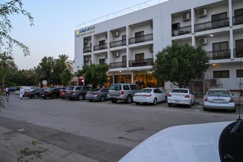 a parking lot with cars parked in front of a building at فندق السليمانيه والرمال الزرقاء in Riyadh