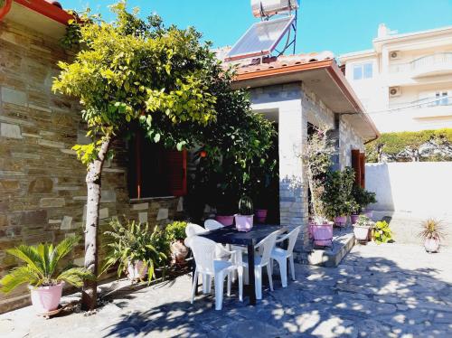 a table and chairs in front of a house at Alba Traditional Countryhouse New Anchialos village in Nea Anchialos