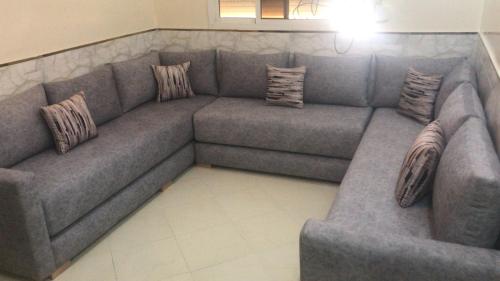 a large gray couch in a living room with pillows at ESC Apartments in Fès