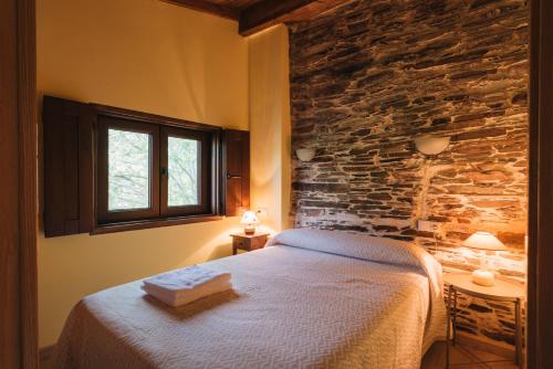 um quarto com uma cama e uma parede de pedra em CASA TRISQUEL 