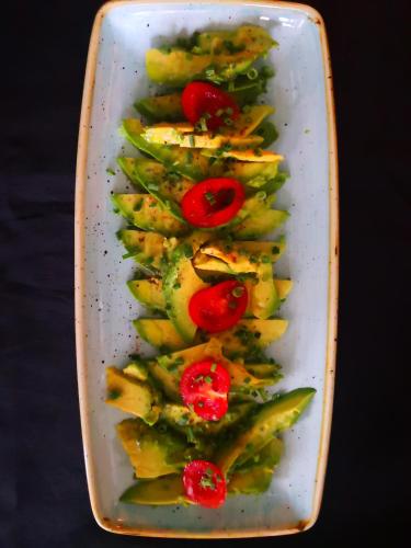 a white plate of vegetables with tomatoes on top at Salotto Brè - Bed & Breakfast charming rooms in Lugano