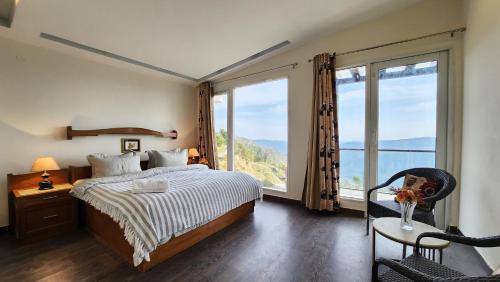 a bedroom with a bed and a large window at Hostie Imperial Chalet-3 BHK Mountain Villa, Chail in Shimla