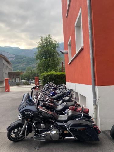 a row of motorcycles parked next to a building at h&ocirc;tel oberland in Le Bourg-dʼOisans