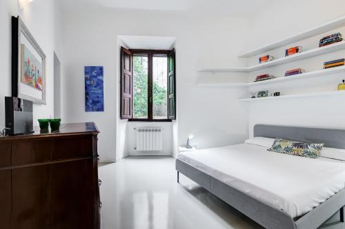 Habitación blanca con cama y TV en Colosseo Exclusive House by Premium Suites Collection, en Roma