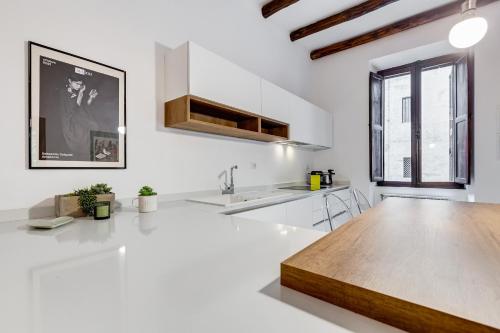 cocina con paredes blancas y mesa de madera en Colosseo Exclusive House by Premium Suites Collection, en Roma