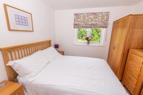 a bedroom with a white bed and a window at The Sheiling in Woolacombe