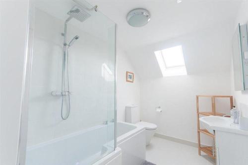 a white bathroom with a shower and a toilet at The Sheiling in Woolacombe