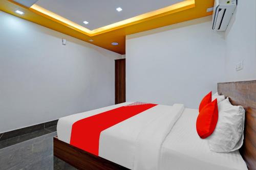 een slaapkamer met een bed met rode en witte kussens bij OYO Flagship Vasudha inn, Hoskote in Bangalore