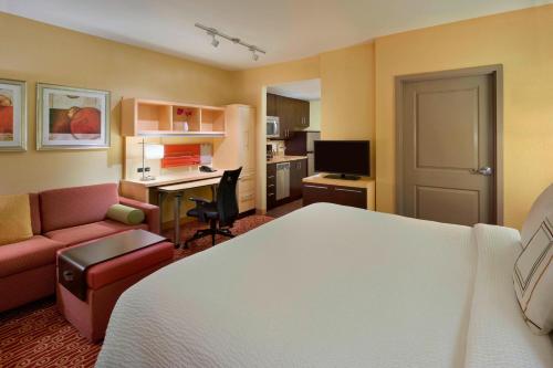 a hotel room with a bed and a desk and a couch at TownePlace Suites by Marriott Thunder Bay in Thunder Bay