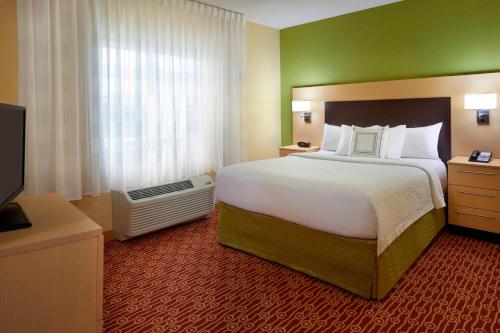 a hotel room with a large bed and a television at TownePlace Suites by Marriott Thunder Bay in Thunder Bay