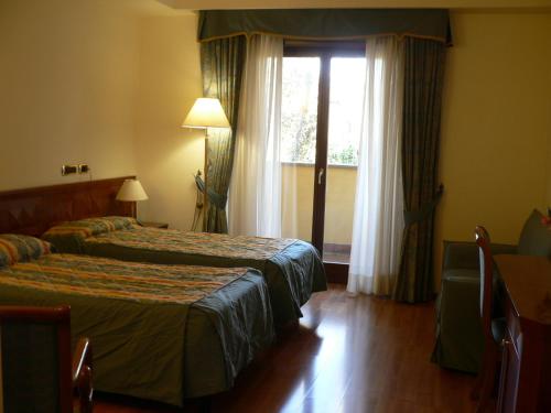 Benito Al Bosco في فليتري: غرفة فندقية بسريرين ونافذة