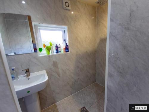 a bathroom with a sink and a shower at Two Bedroom Penicuik Apartment in Penicuik