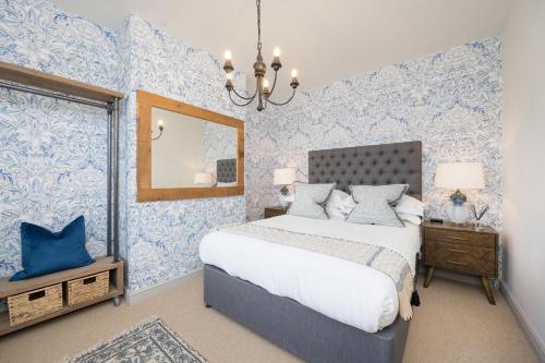 a bedroom with blue and white wallpaper and a bed at Townhouse by Harrogate Serviced Apartments in Harrogate