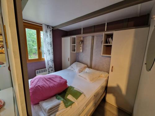 - un petit lit dans une petite chambre avec fenêtre dans l'établissement Chalet de Caralba Piscine, à Ghisoni
