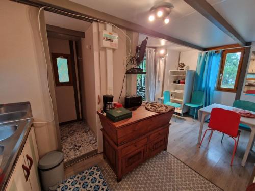 - une cuisine avec une commode en bois, une table et des chaises dans l'établissement Chalet de Caralba Piscine, à Ghisoni