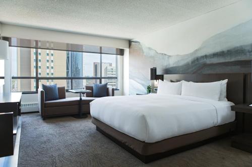 a bedroom with a large white bed and a large window at Calgary Marriott Downtown Hotel in Calgary