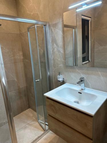 uma casa de banho com um lavatório e um chuveiro em Ewa Apt - 3-Bedrooms Apt near Sliema - St Julians Seafront em Il-Gżira