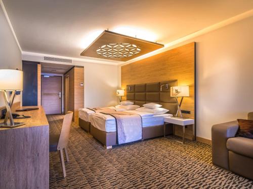 a hotel room with two beds and a desk at Rezydencja Nosalowy Dwór in Zakopane