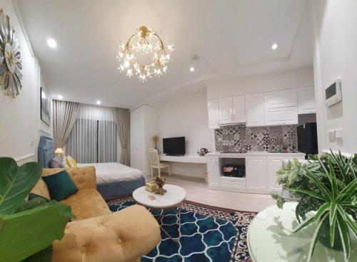 un grand salon avec un lit et un lustre dans l'établissement Luxury econest - Apartment with swimming pool & gym, à Hanoï