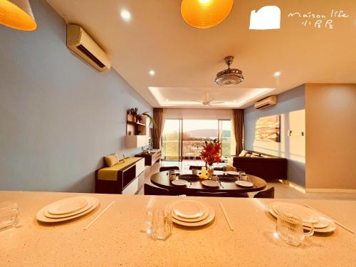 a kitchen and living room with a table with plates on it at Maison life 小居屋 The Loft Imago in Kota Kinabalu