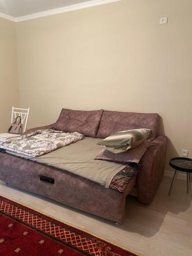 ein Sofa mit Kissen darauf im Zimmer in der Unterkunft Жк Абырой Ризеденс in Atyrau