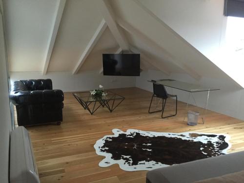 a living room with a black leather couch and a table at Solar Do Castelo - Melgaço in Melgaço