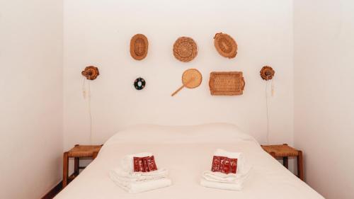 a bed in a room with baskets on the wall at The Blue House Valley in Grândola