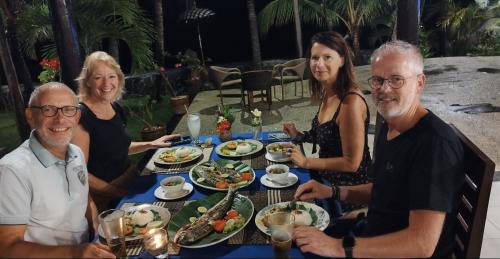 a group of people sitting around a table eating food at 1000 Dream Bungalow in Lovina