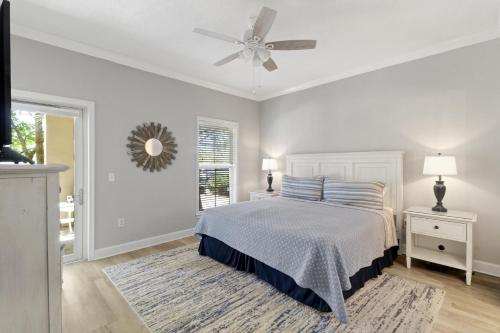 een witte slaapkamer met een bed en een plafondventilator bij 103 North Shore Place in Hilton Head Island
