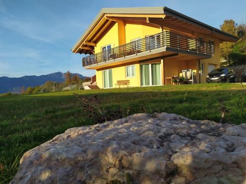 una casa con una gran roca delante de ella en Il Biancospino Appartamento in Villa, 